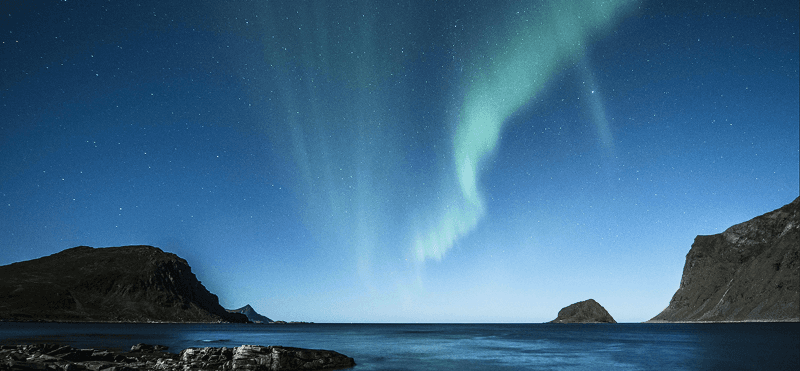 Aurora boreal sobre um fiorde na Islândia